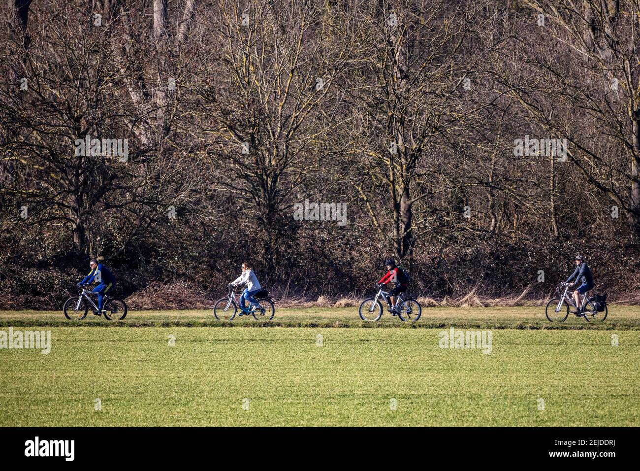 People and cyclists enjoy the warm winter sunshine in February in Mülheim an der Ruhr, Germany Stock Photo