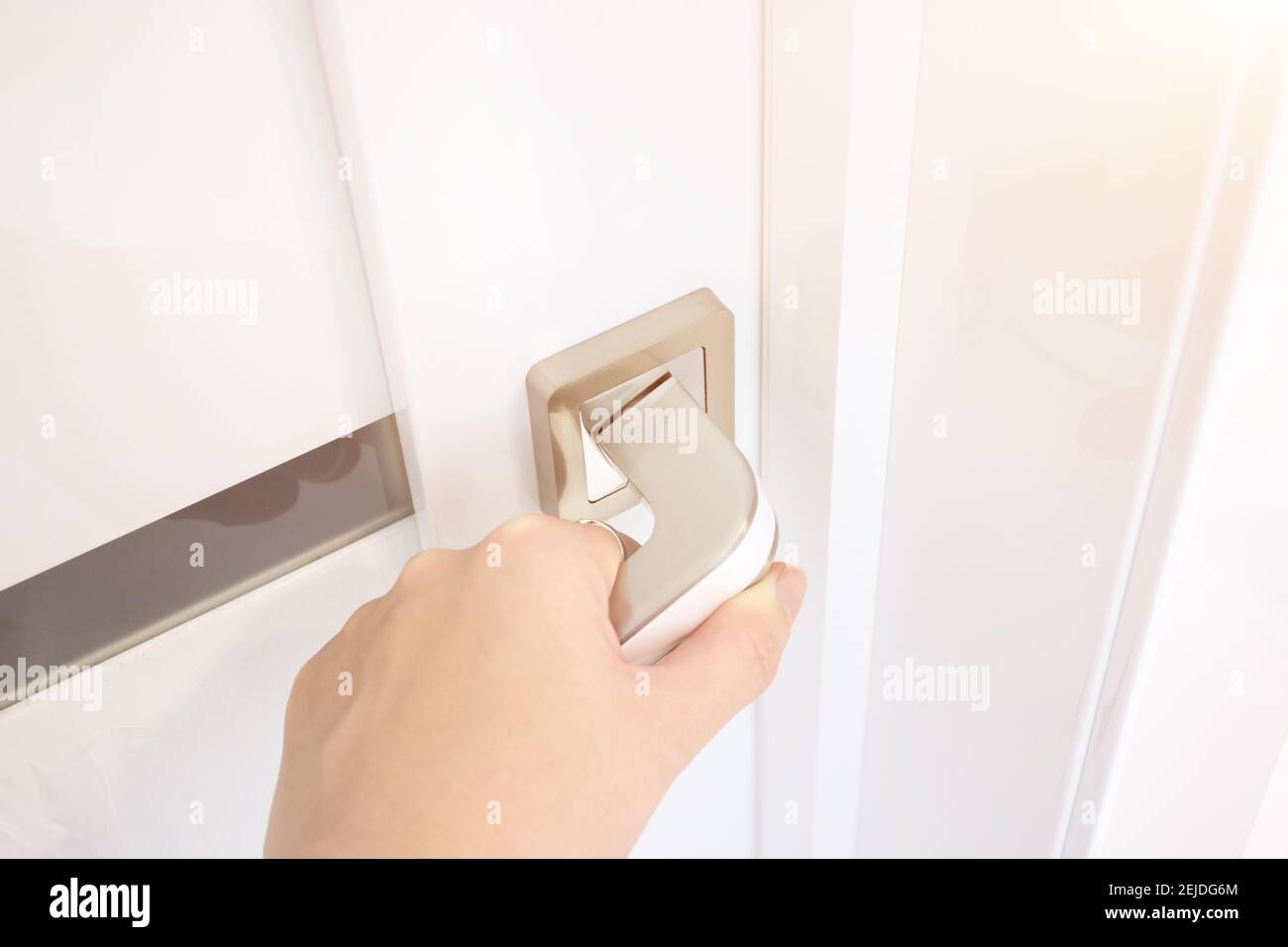 Close-Up Of Hand Opening Door. Hand Holding Chrome Doorknob. Stock Photo