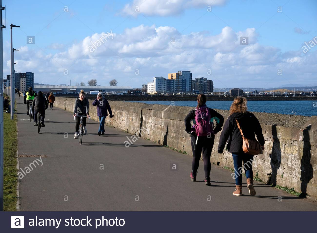 Edinburgh, Scotland, UK. 22th Feb 2021. People make the most of the outdoors on a cold and sunny afternoon on Mckelvie parade at Granton by the shore.  Credit: Craig Brown/Alamy Live News Stock Photo