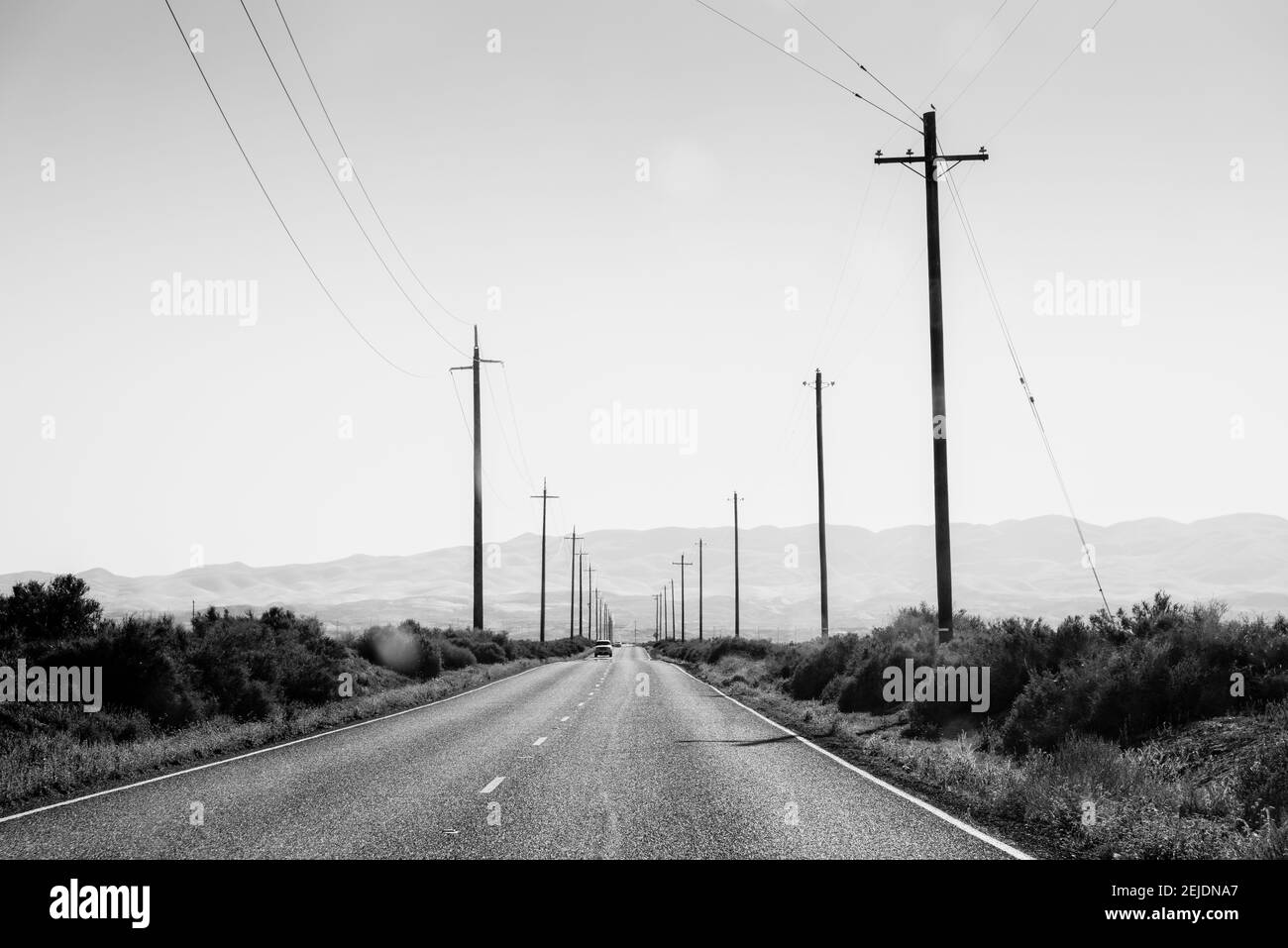 Electric poles on both sides of a road, Bakersfield, Kern County, California, USA Stock Photo