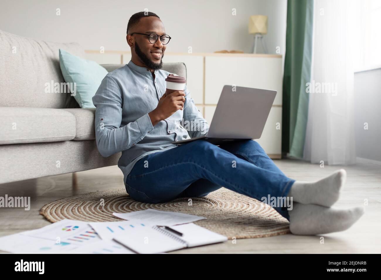 Happy African Freelancer Man Using Laptop Working From Home Stock Photo
