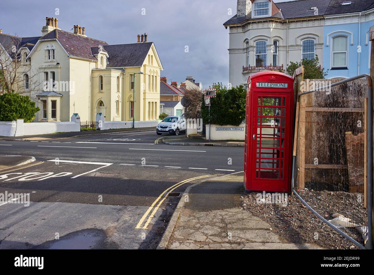 Red K6 style phone box at May Hill in Ramsey on the TT course next to the White Gates bend sign Stock Photo