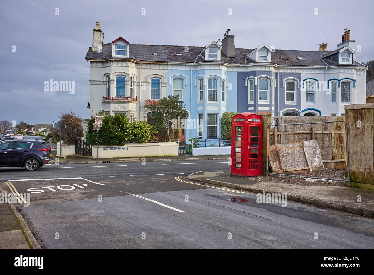 Red K6 style phone box at May Hill in Ramsey on the TT course next to the White Gates bend sign Stock Photo