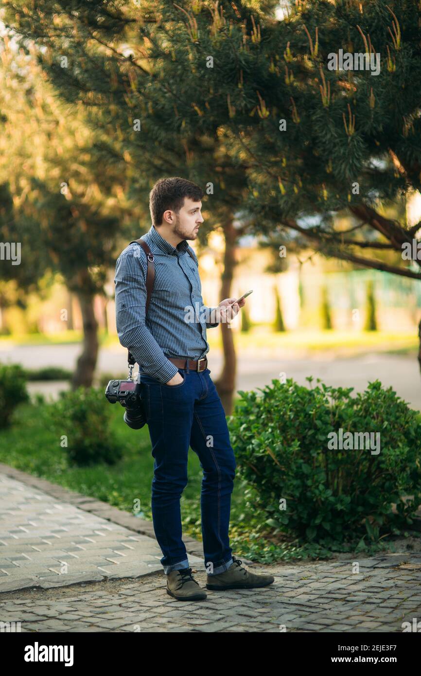 Portrait of professional photographer outside. Man use best camera and