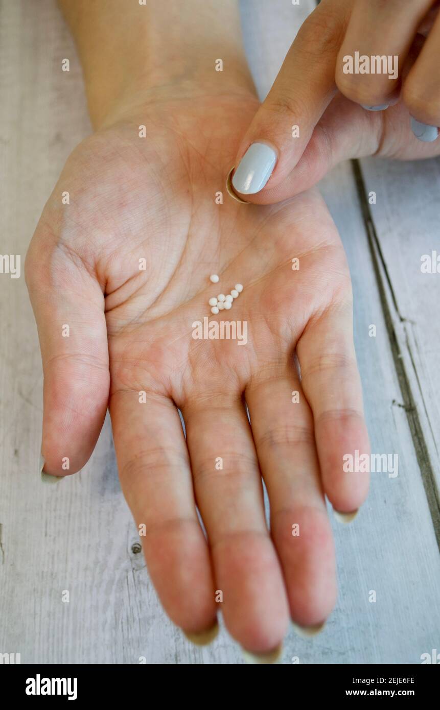 Open woman's hand on which several globoli lie Stock Photo
