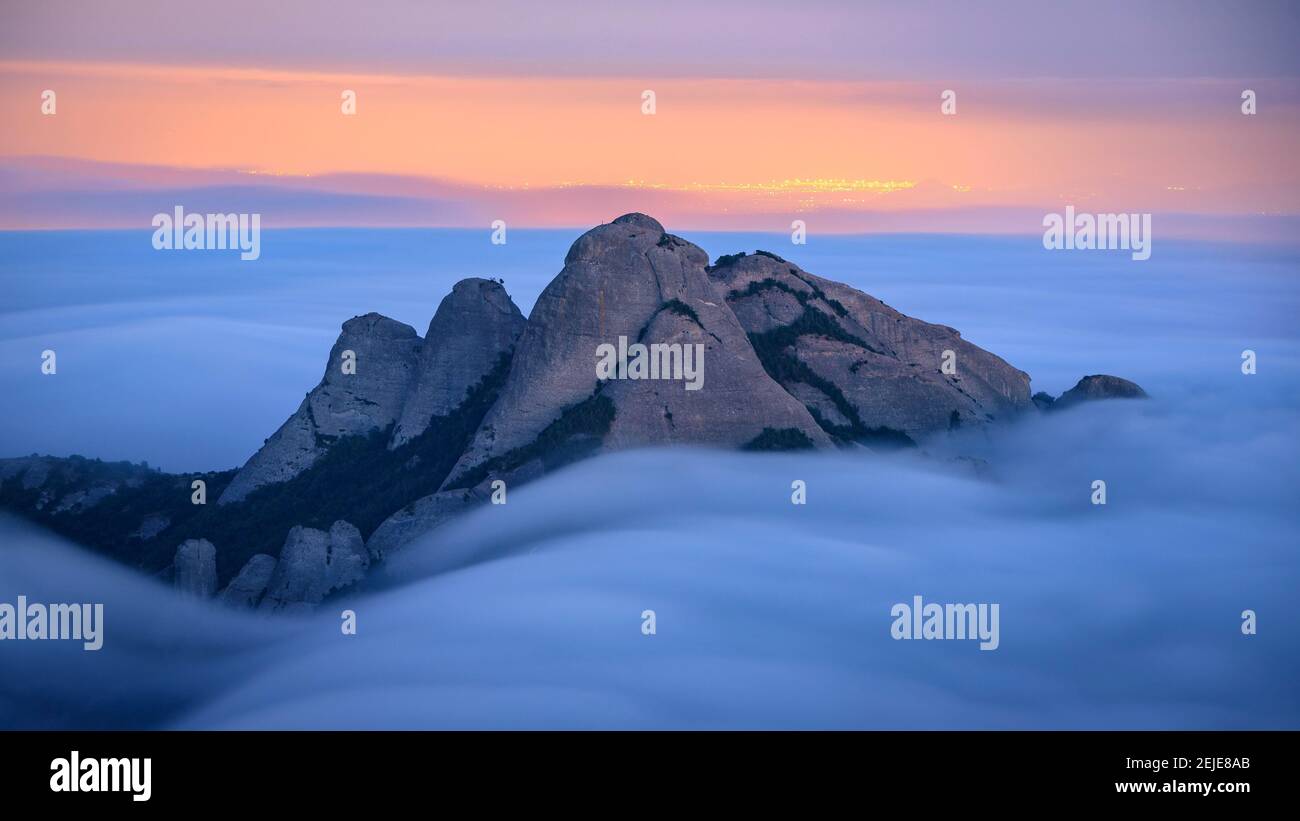 Blue hour at twilight in Montserrat with fog looking to the spires of Gorres and Magdalenes seen from the Sant Jeroni summit (Barcelona, Cataluña) Stock Photo