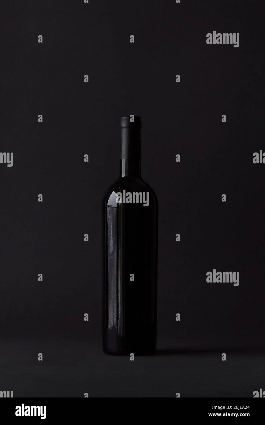Bottle of red wine on black background Stock Photo - Alamy
