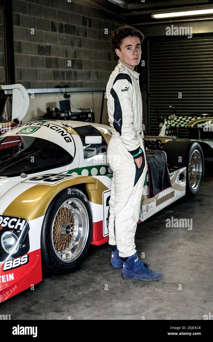 Young racer standing with car in garage Stock Photo Alamy