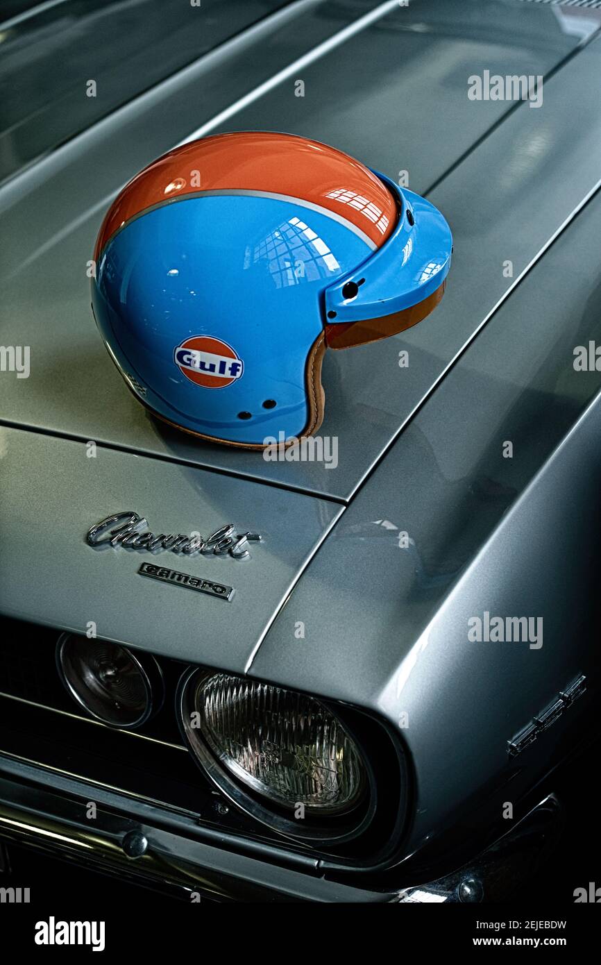Close up of helmet on car hood . Vintage helmet on classic American 1967 Chevrolet Camaro car bonnet . Stock Photo