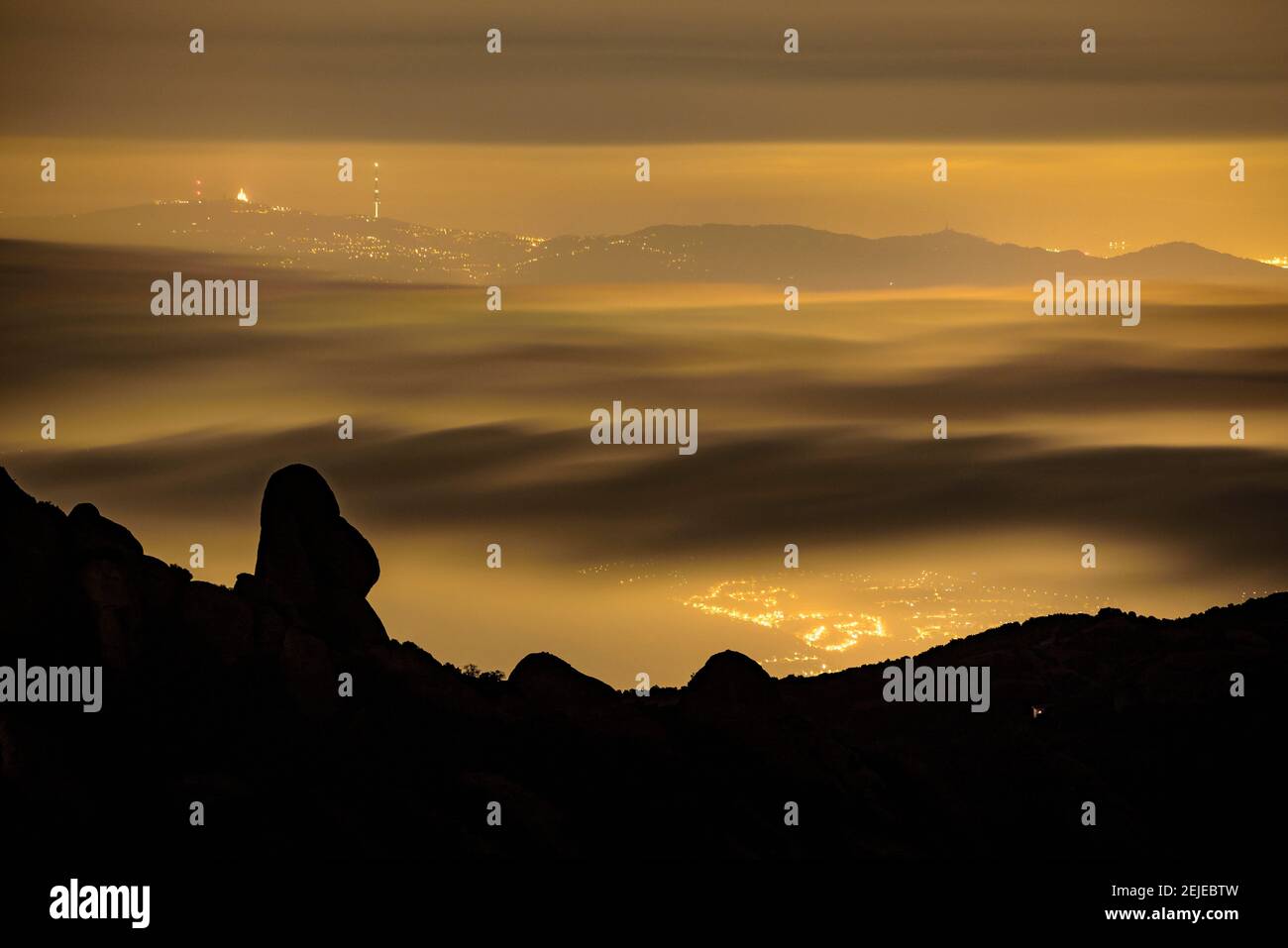 Night in Montserrat with fog looking to La Prenyada peak, seen from the Sant Jeroni summit (Barcelona region, Catalonia, Spain) Stock Photo