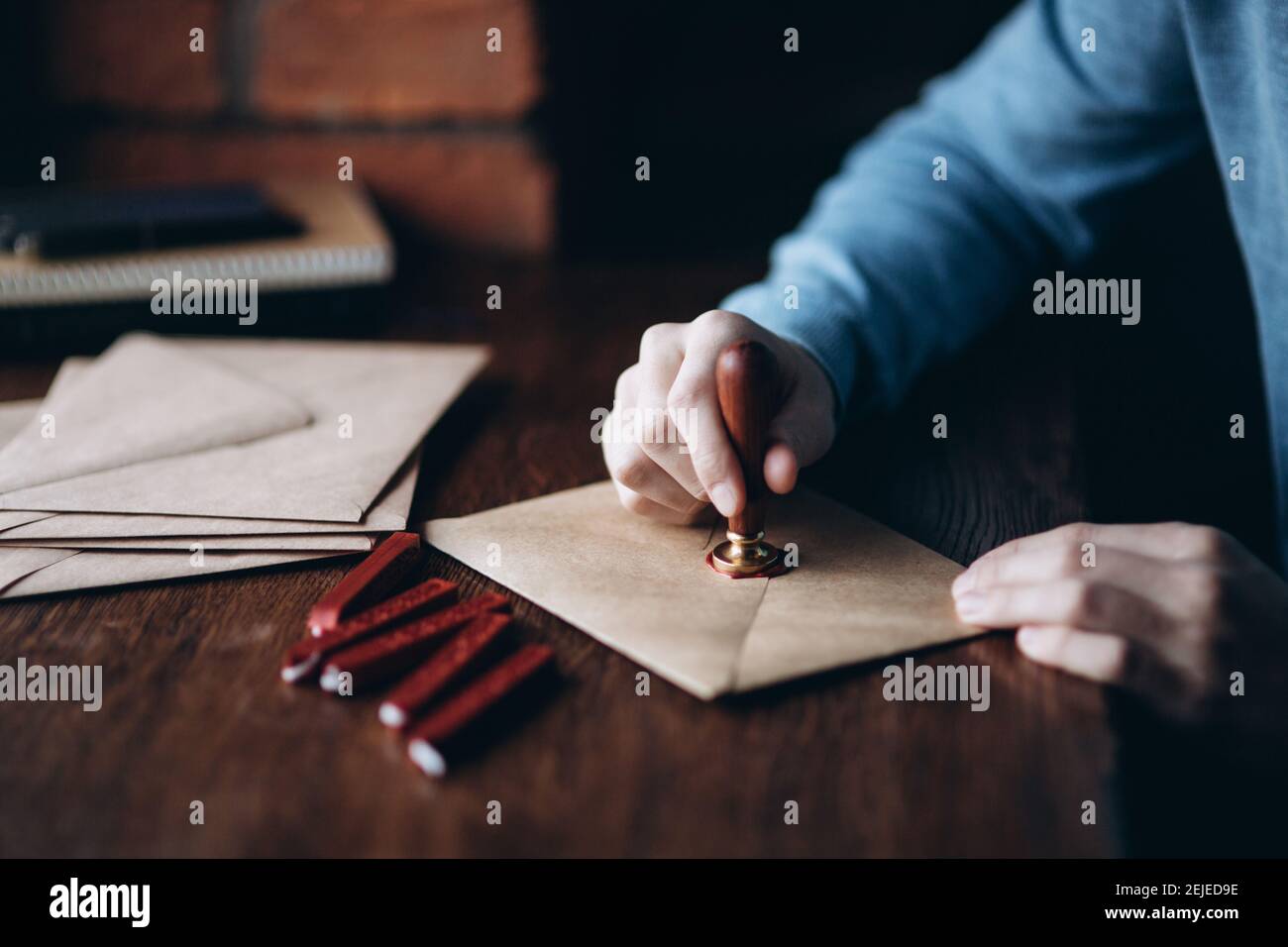 Man makes the stamp using sealing wax on the envelope Stock Photo