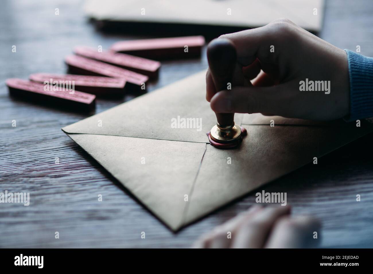 Man makes the stamp using sealing wax on the envelope Stock Photo