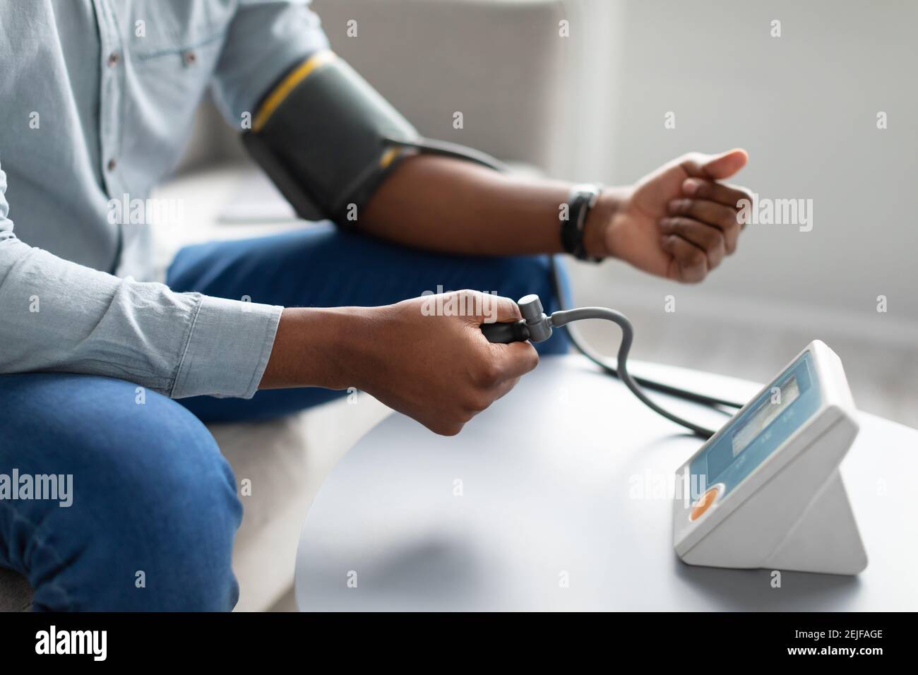 Black Man Measuring Arterial Blood Pressure Having Hypertension Indoors, Cropped Stock Photo