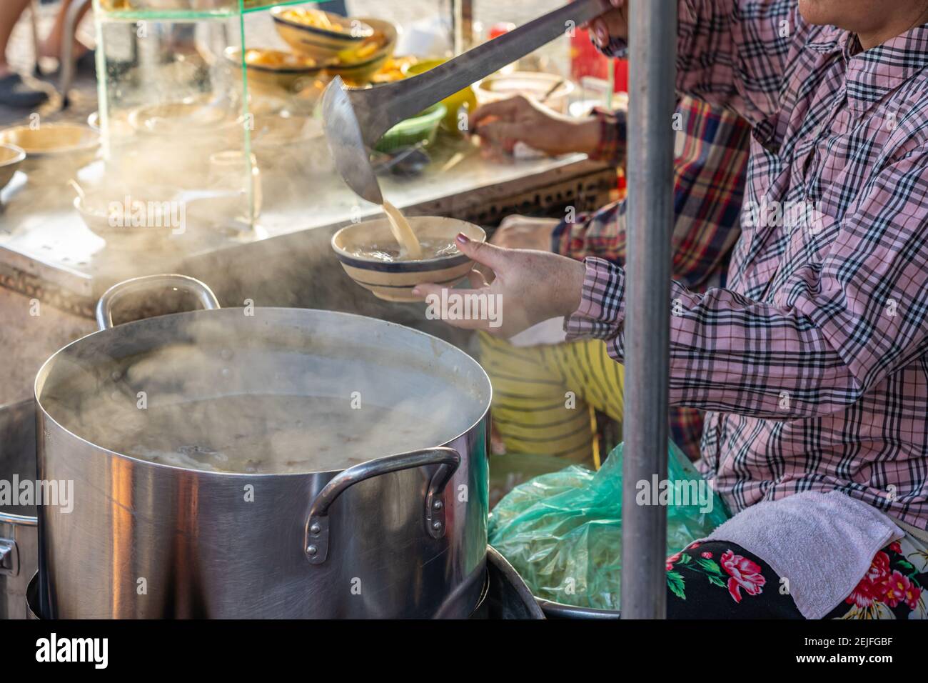 Vietnamese woman selling pig organs porridge at street food vendor Stock Photo
