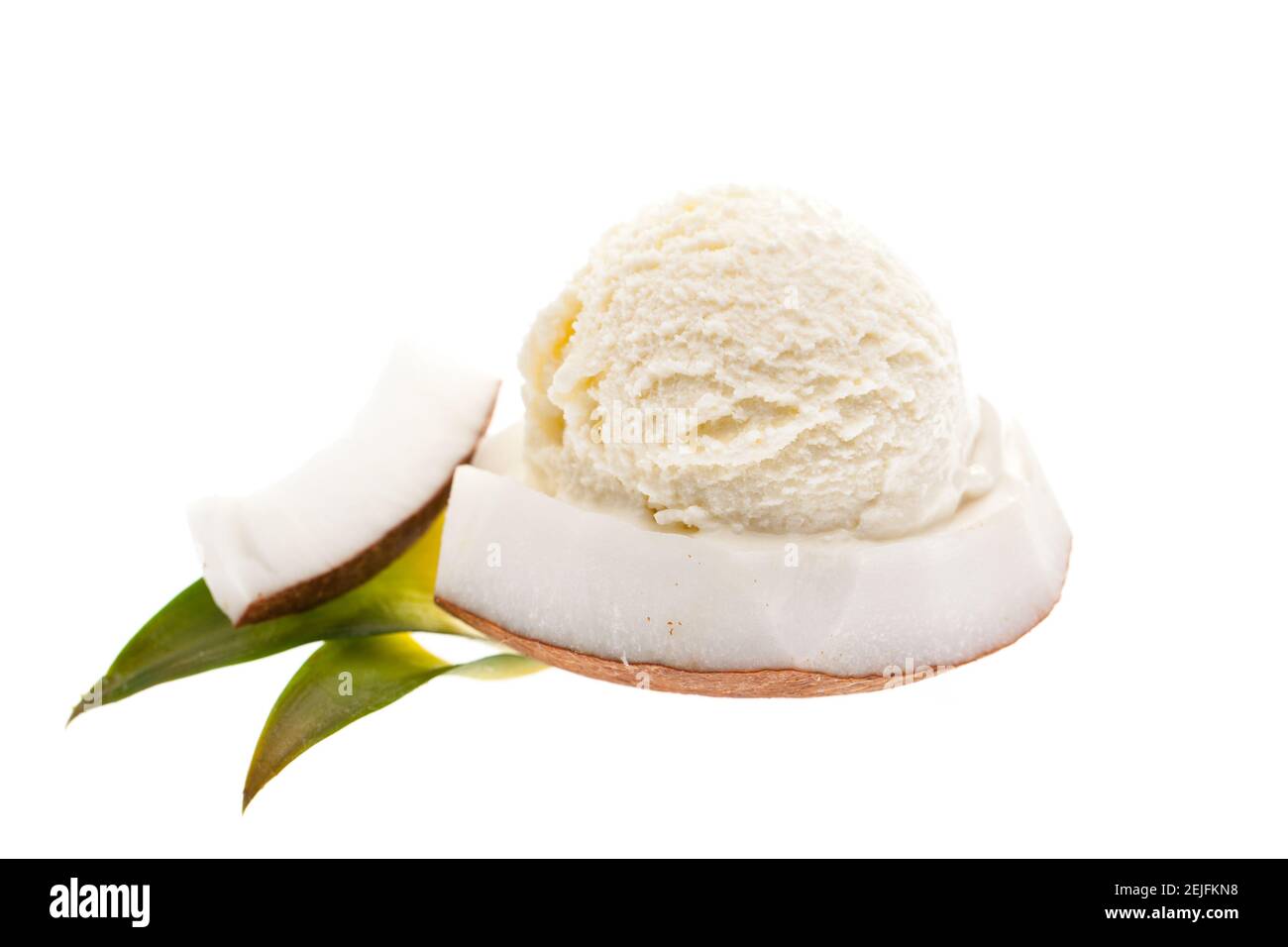 a scoop of coconut ice cream on top of a piece of coconut isolated on white background Stock Photo