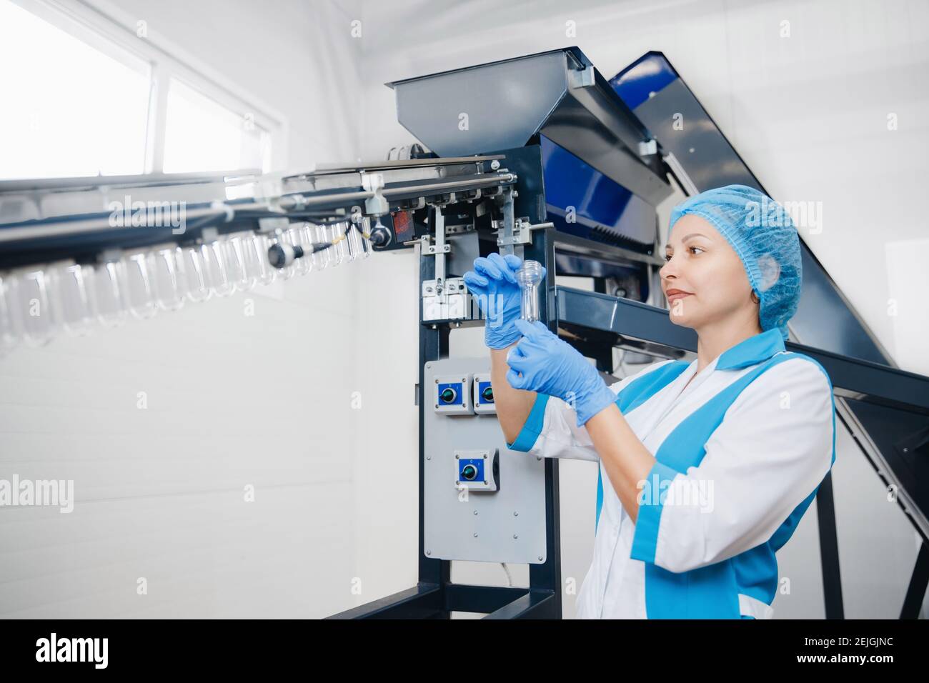 Engineer worker woman checks plastic preform. Production of PET bottles