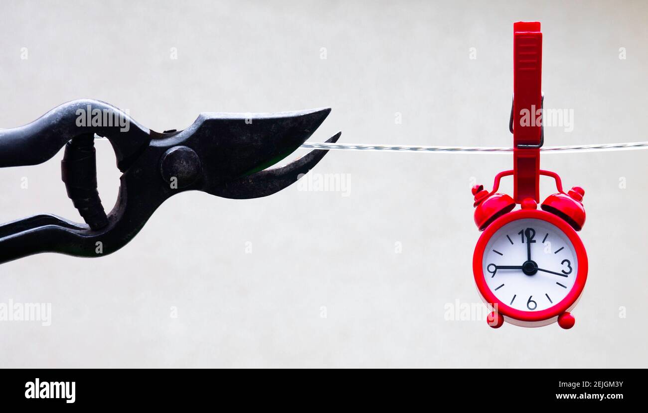 Cutting a rope with a clock hung on by a clip. Go freelance Stock Photo ...