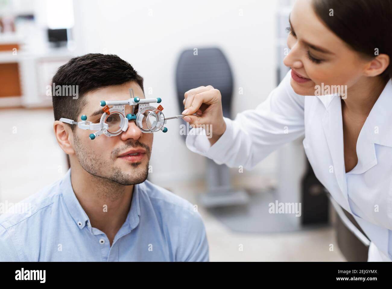 Optometrist checking male patients vision with trial frame Stock Photo