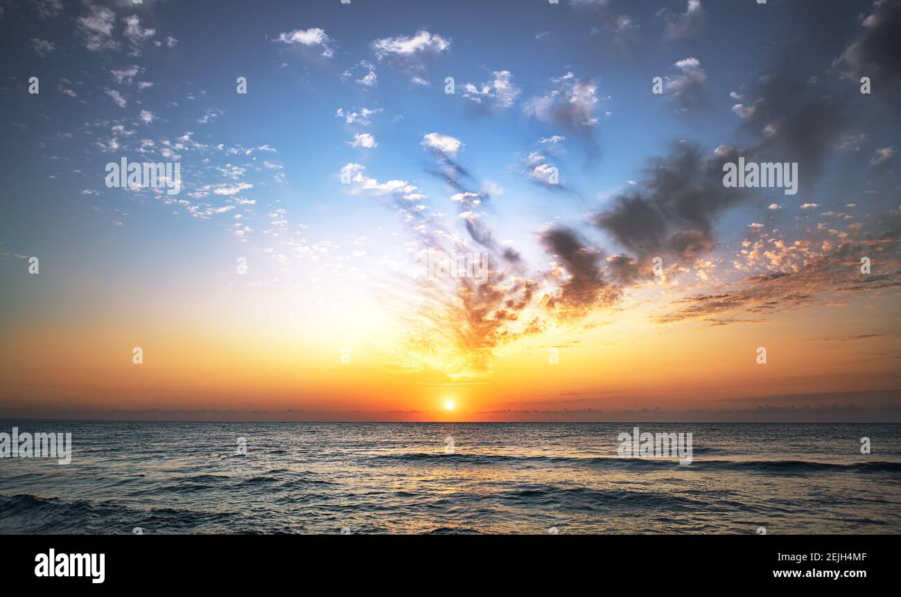 Beautiful sunset sky above clouds over the ocean. Stock Photo