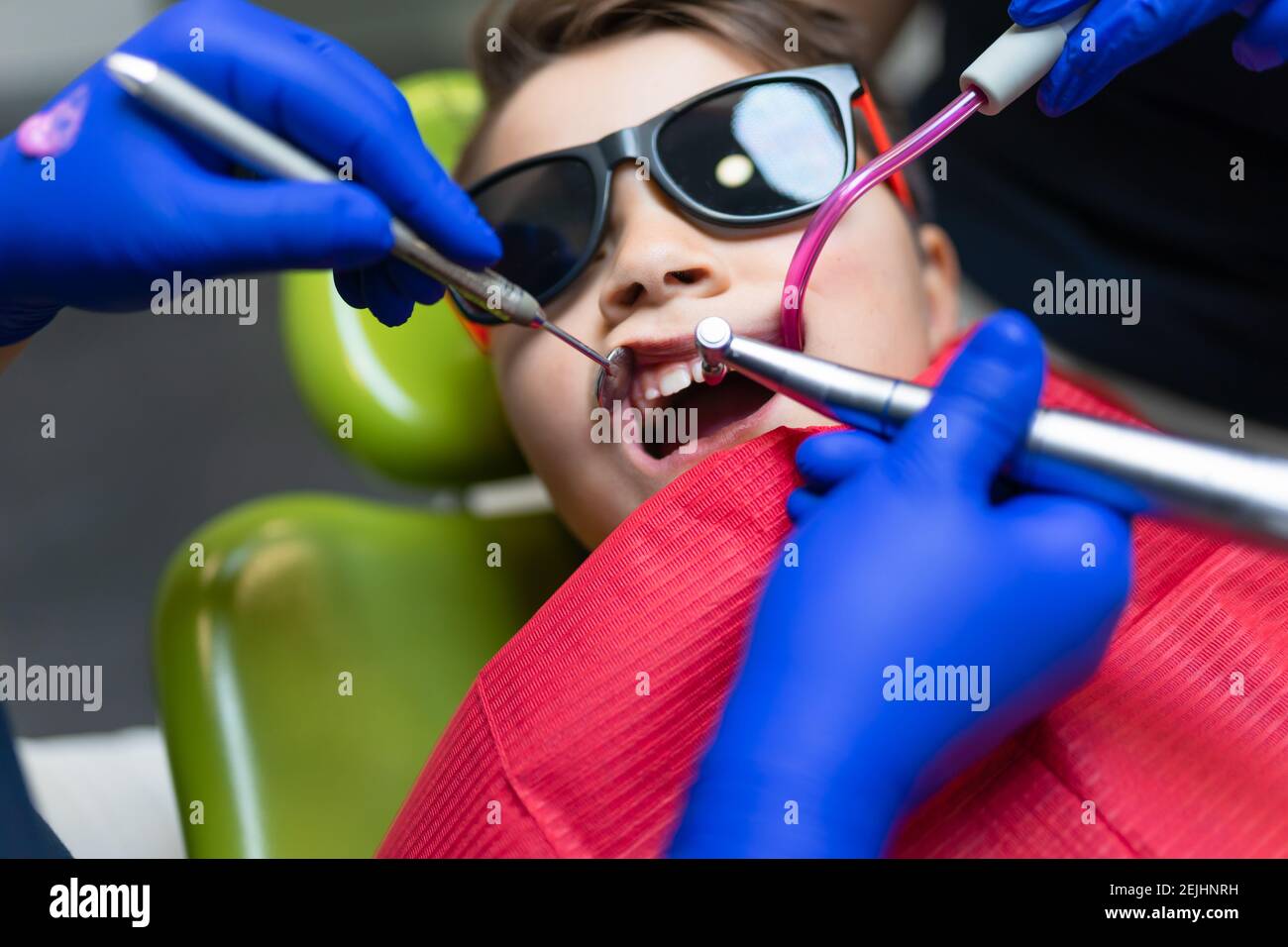 Dentist and assistant make preventive dental plaque cleaning for