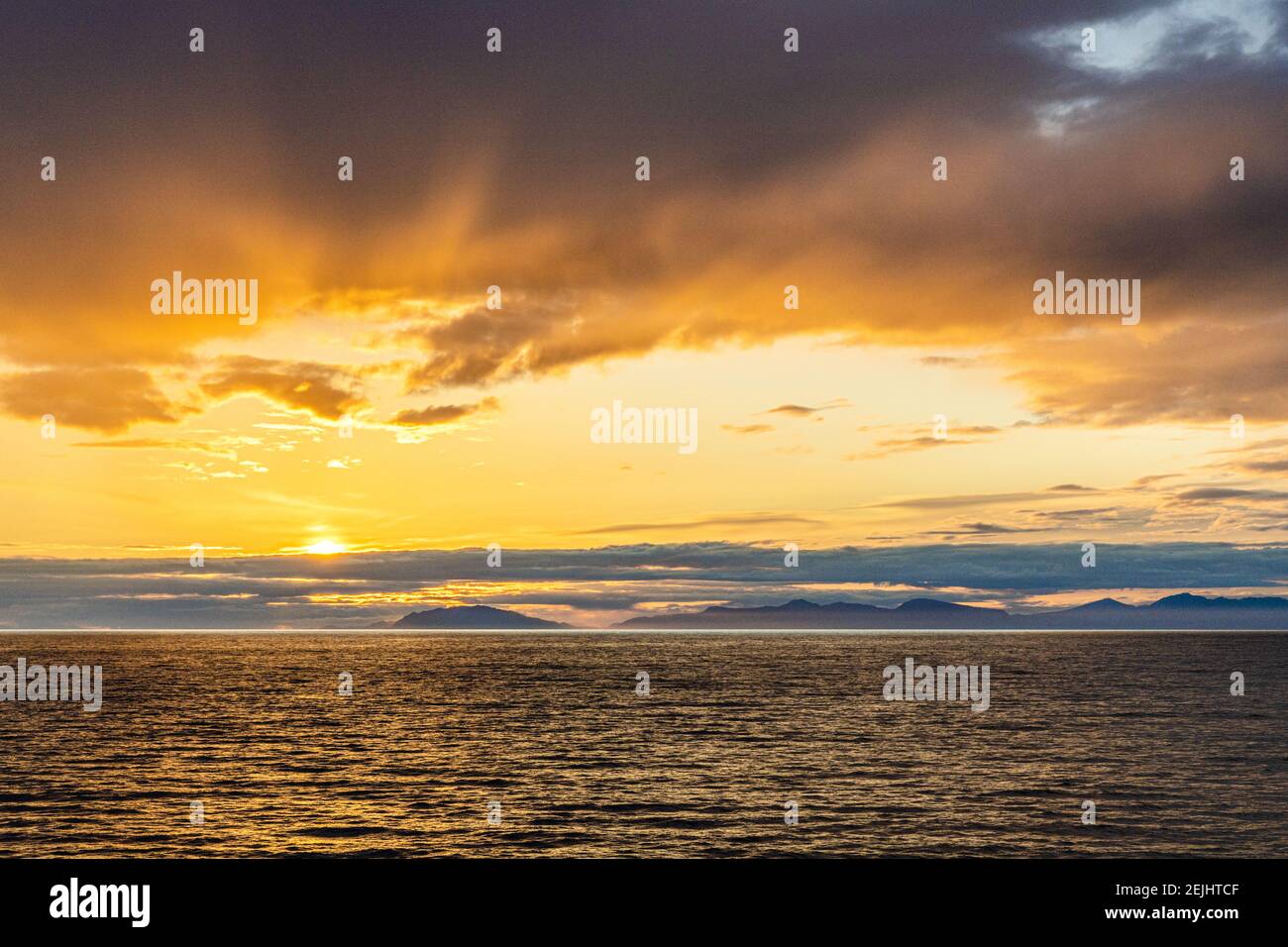 A sunset over the NW Pacific coast near Prince of Wales Island, Alaska, USA - Viewed from a cruise ship sailing the Inside Passage Stock Photo