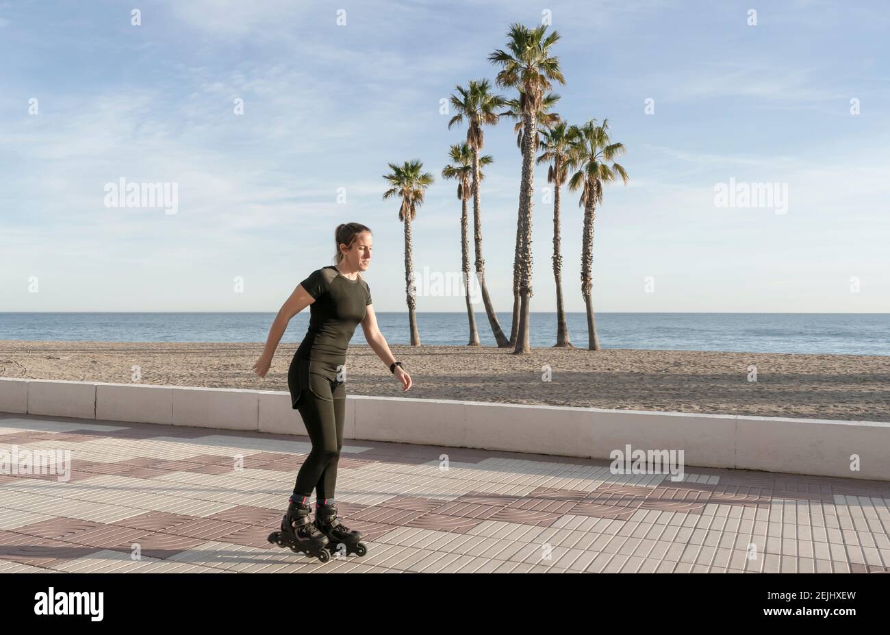 Beautiful fit woman roller skating in promenade at the seaside with palm  trees on background.Sport and fitness lifestyle concept with copy space  Stock Photo - Alamy