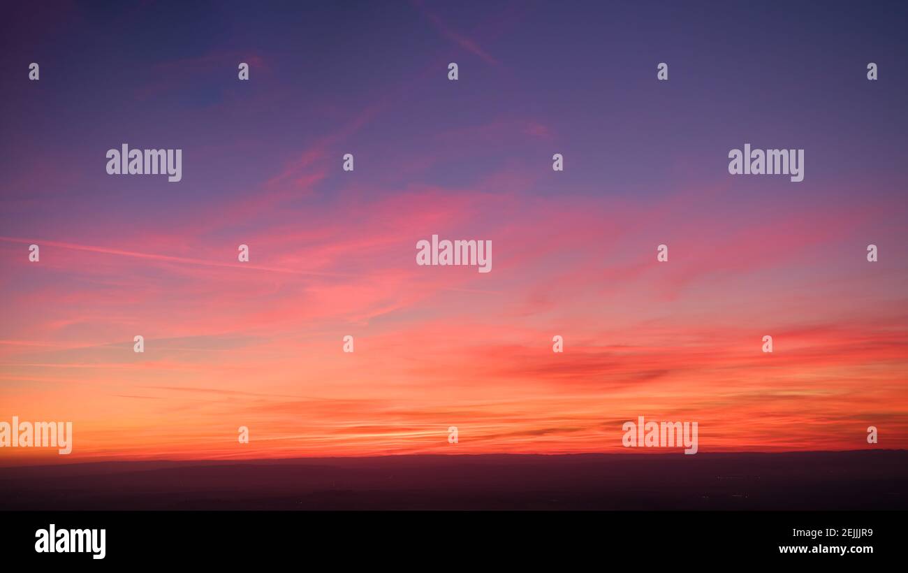 Evening colorful purple-pink sky with red clouds and orange horizon. Aerial photography, sky over the whole photo. Photo perfect for background exchan Stock Photo