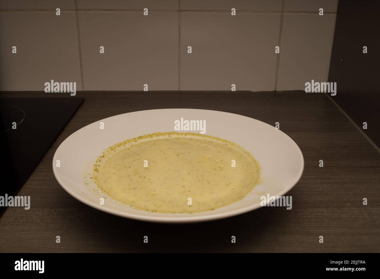 Brokkolicremesuppe in einem weißen Suppenteller Stock Photo