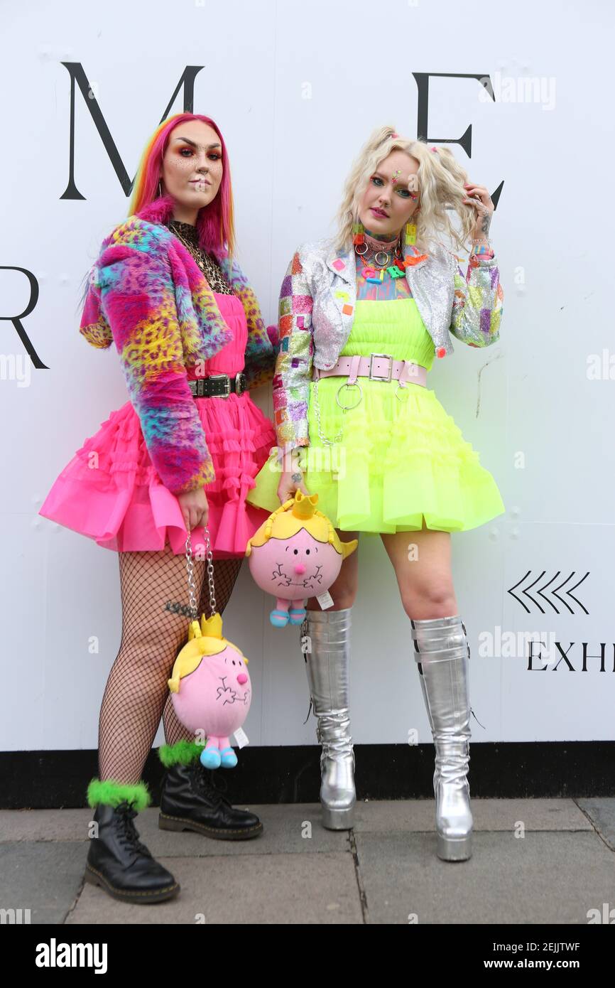 Ladies wearing colourful outfits pose 