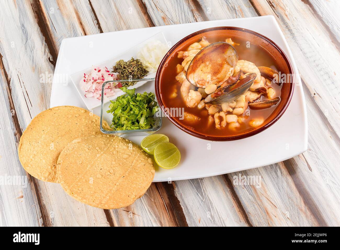 Closeup to a Mexican seafood Pozole dish on a restaurant table Stock Photo
