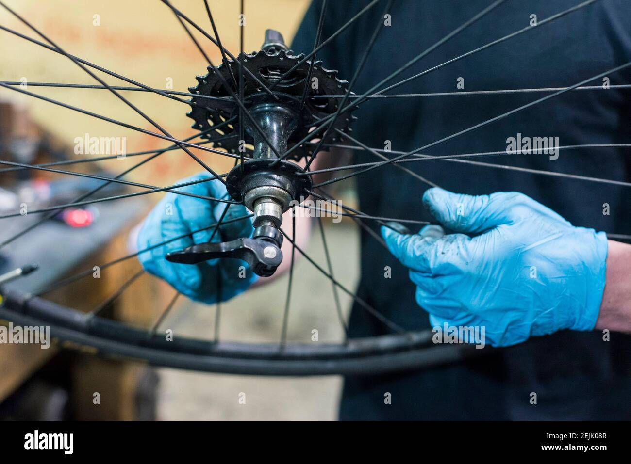 A close up shot of the hands of a bike mechanic servicing the rear