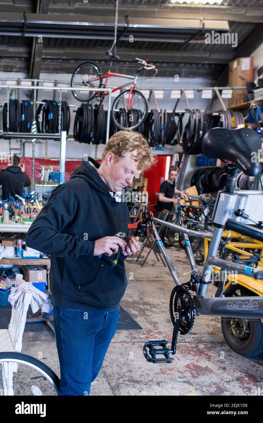 A bike mechanic works on fixing a bike in a cycle industry business