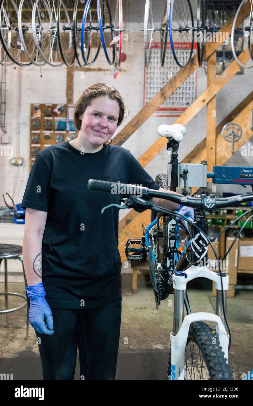 A female bike mechanic stands at her work stand in a cycle servicing repair workshop Stock Photo Alamy