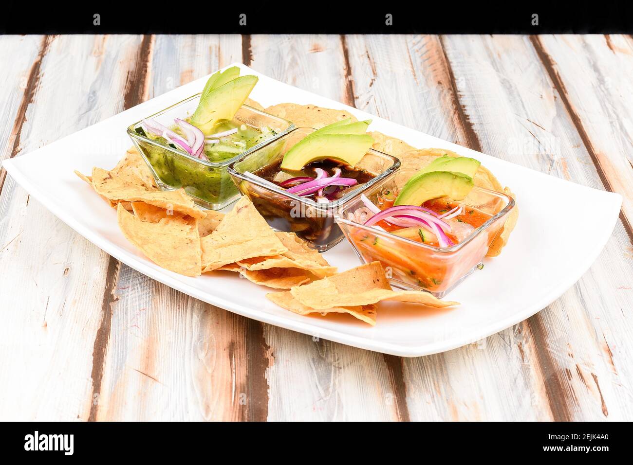 Plate with ceviches prepared with different sauces accompanied with tortillas or avocado Stock Photo