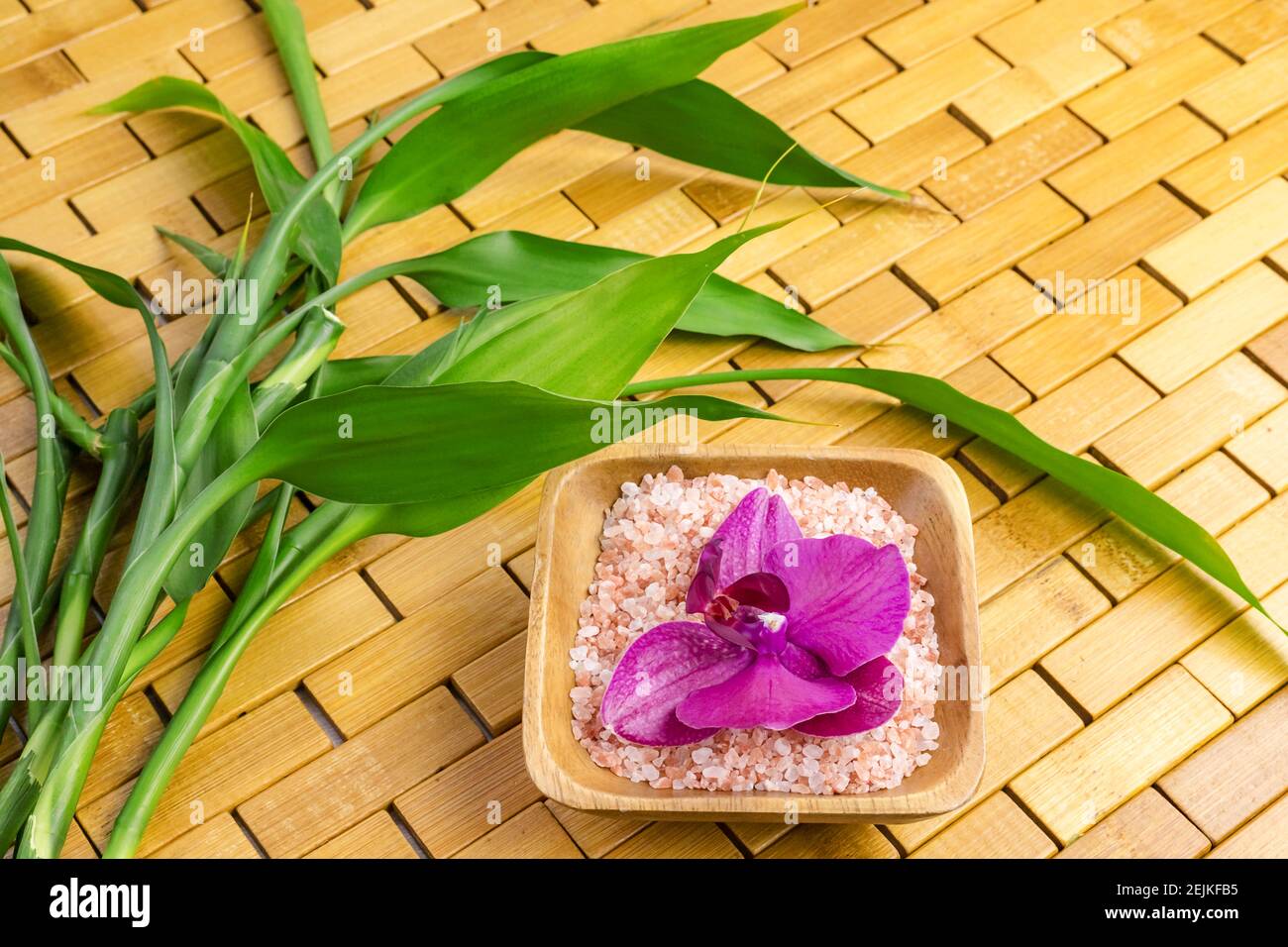 Spa, zen, massage concept. Pink himalayan bath salt, bamboo leaves, orchid, soap dish Stock Photo