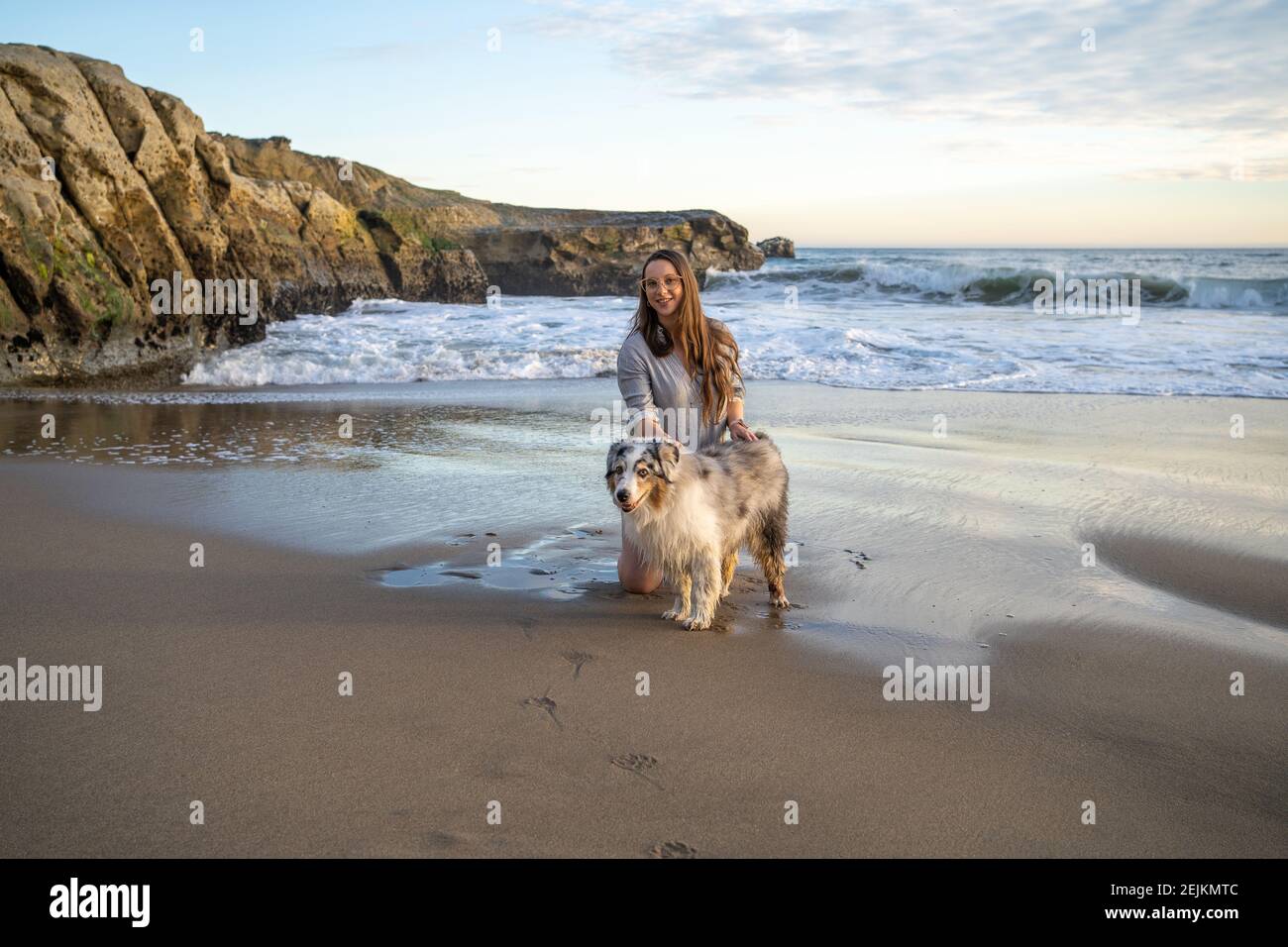 Girl with Australian Shepherd (aussie) at Sunset on the Beach Stock Photo