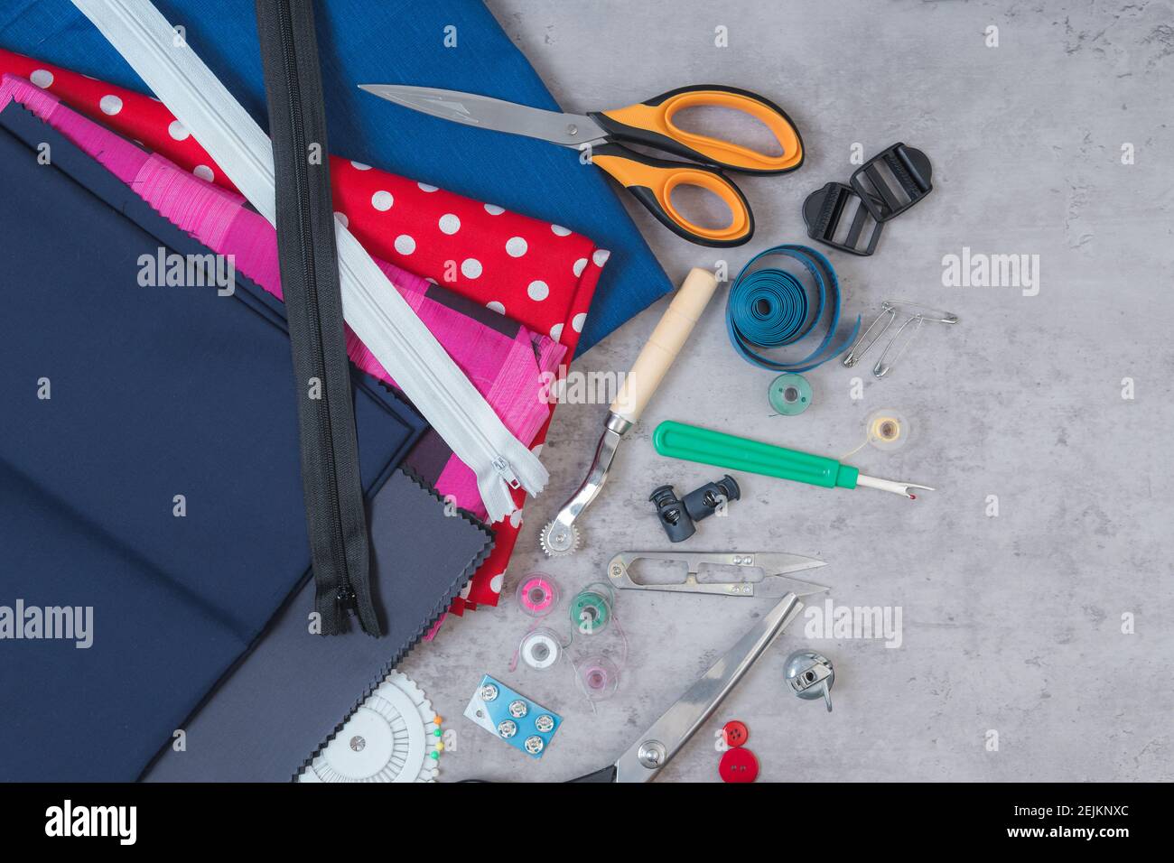 Cloth, buttons, zipper, tape measure, tools of a tailor on a table ...