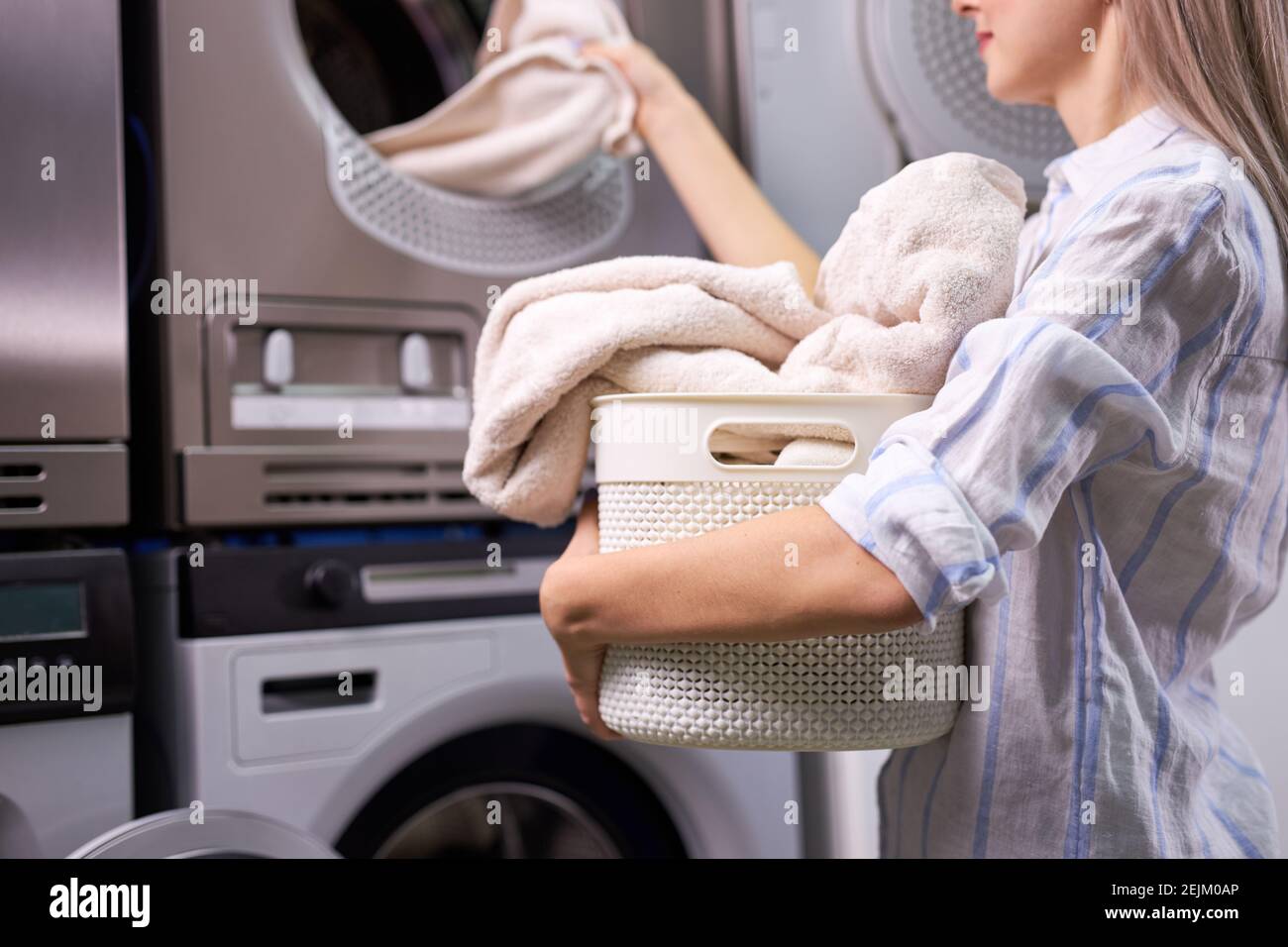 woman doing laundry - putting out white garments from washing machine ...
