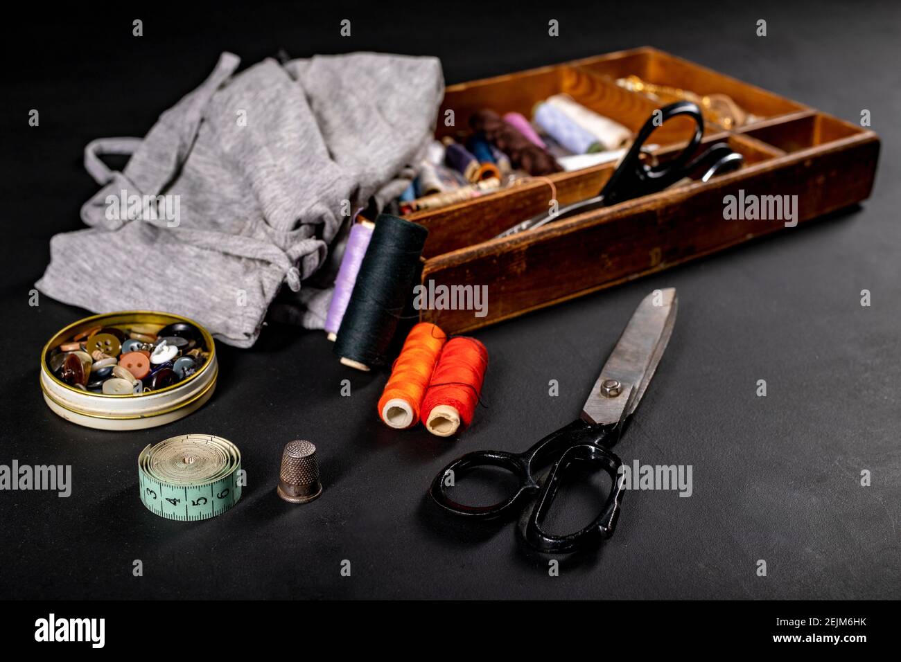 Utensils on the table in the tailor's workshop. Accessories necessary for tailoring. Dark background. Stock Photo