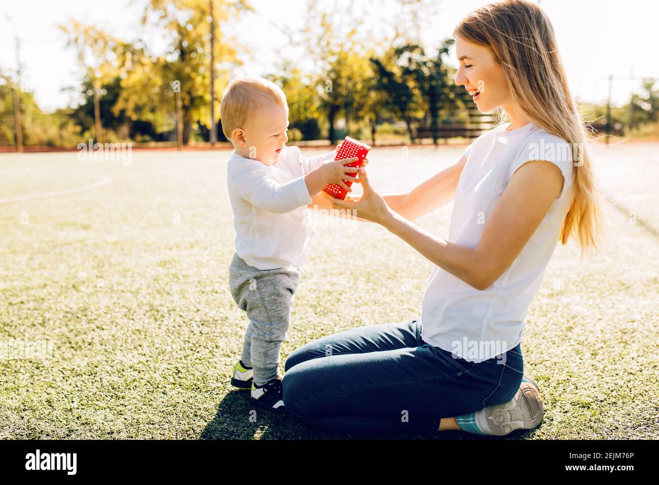 https://c8.alamy.com/comp/2EJM76P/happy-loving-family-mother-and-child-little-boy-makes-a-gift-to-mom-for-mothers-day-in-the-park-2EJM76P.jpg