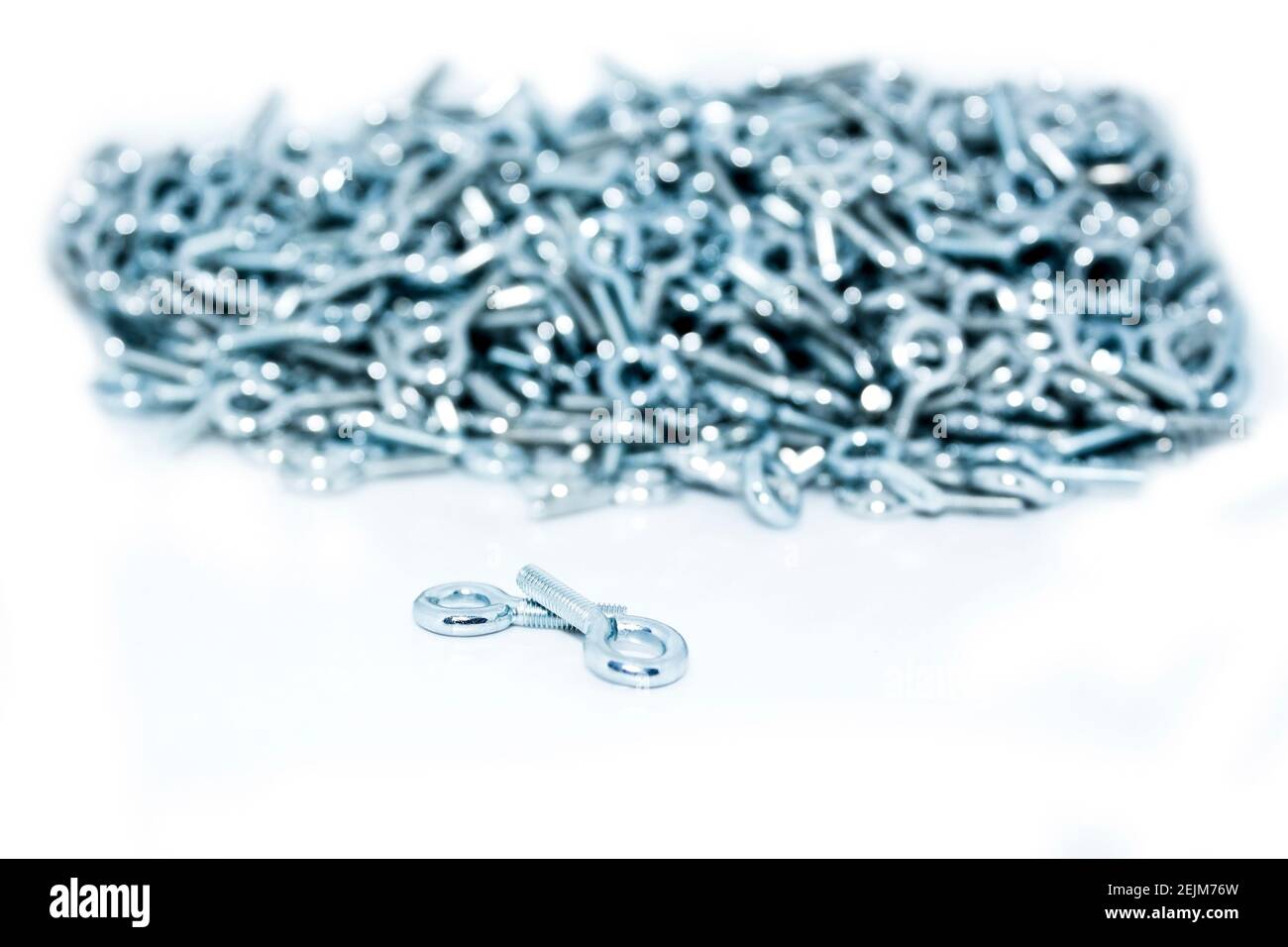 Lots of big industrial galvanized eye bolts on a pile on white background Stock Photo