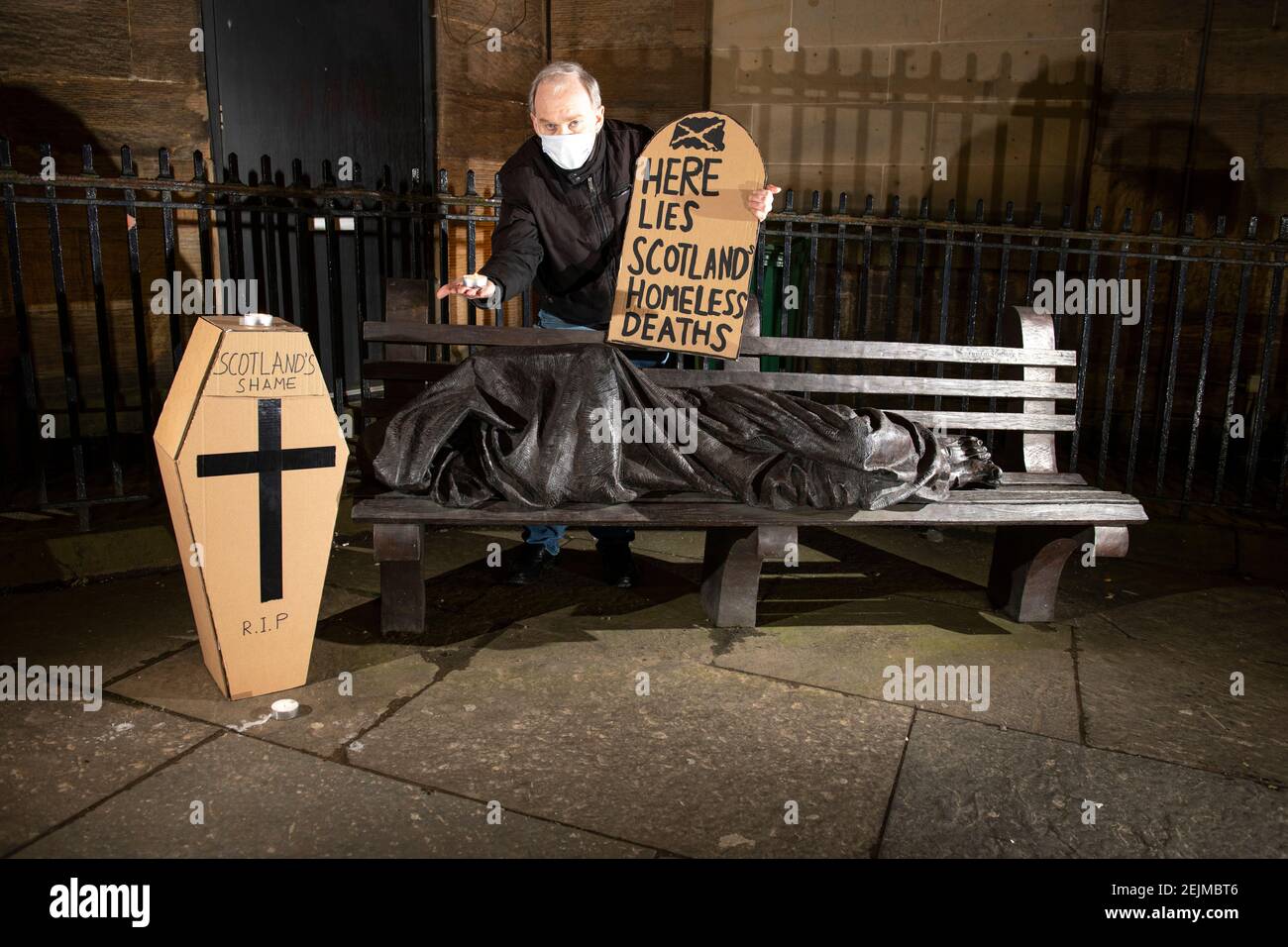 Glasgow, Scotland, UK. 22nd Feb, 2021. Pictured: Sean Clerkin - Scottish Tenants Organisation, holding a gravestone shaped placard which reads, “HERE LIES SCOTLANDS HOMELESS DEATHS”. Today 23rd Feb 21, the Scottish Government has released the homeless deaths figures 3 days early which are up by an increase of 11% from last year. The link https://www.nrscotland.gov.uk/news/2021/homeless-deaths-2019 shows the article today. Credit: Colin Fisher/Alamy Live News Stock Photo