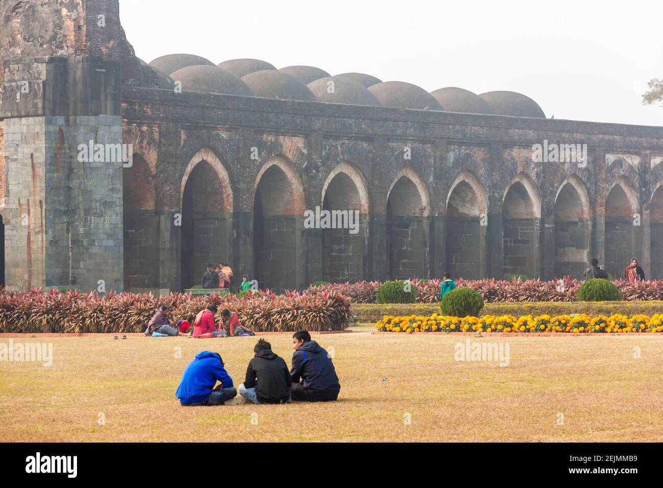 Malda, West Bengal, India - January 2018: Tourists sitting in the gardens of the ancient Adina Masjid mosque in the village of Pandua. Stock Photo
