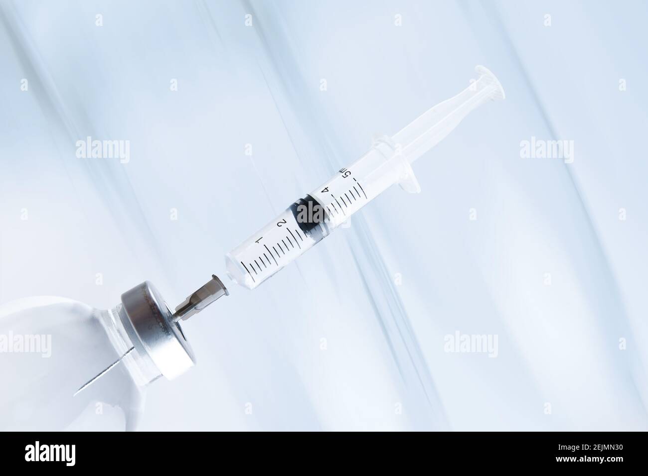 medicine bottle with a syringe stuck into the cap Stock Photo Alamy