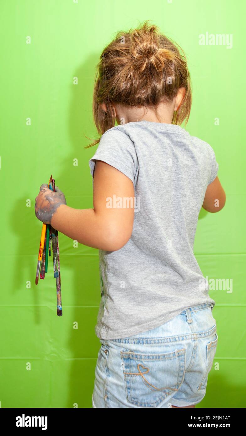 Young girl is about to paint on the wall. Green Screen Stock Photo Alamy