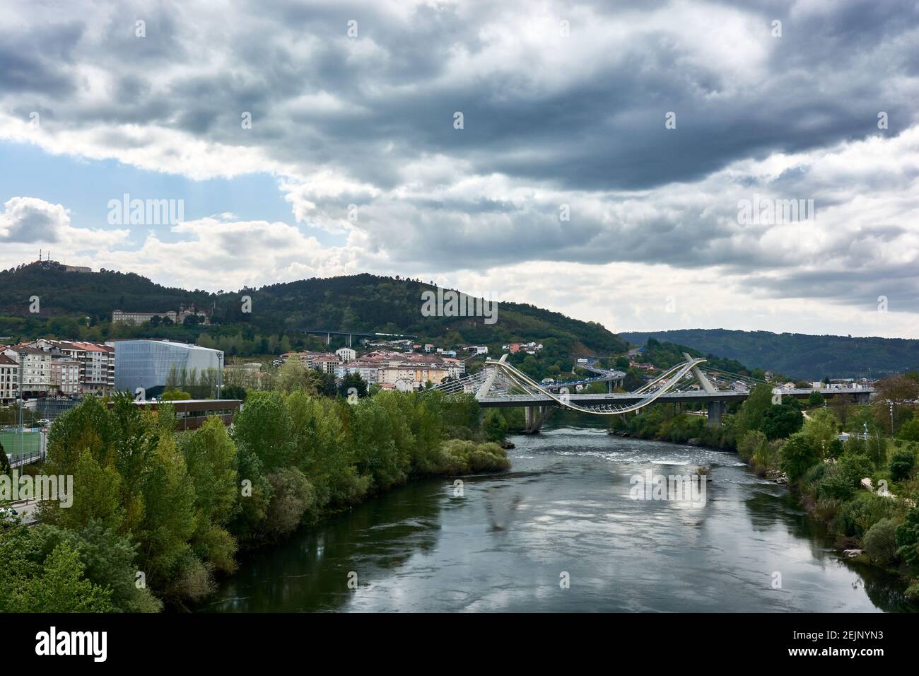 Cityscape with view of the Millenium Bridge on the Minho River seen from the Roman Bridge in the picturesque medieval city of Ourense in Galicia, Spai Stock Photo