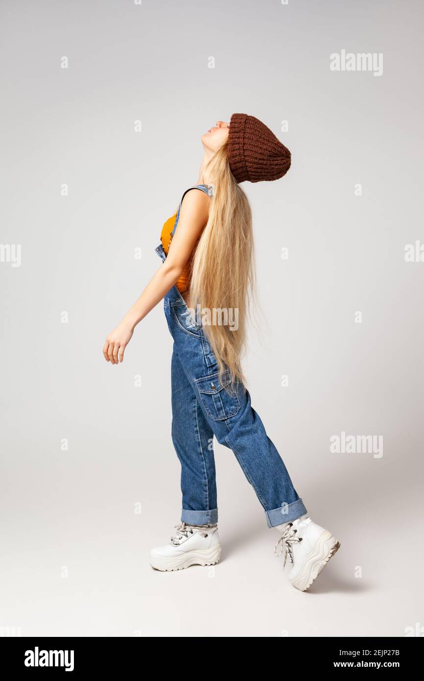 Energetic hipster woman in trendy wear dancing in studio Stock Photo