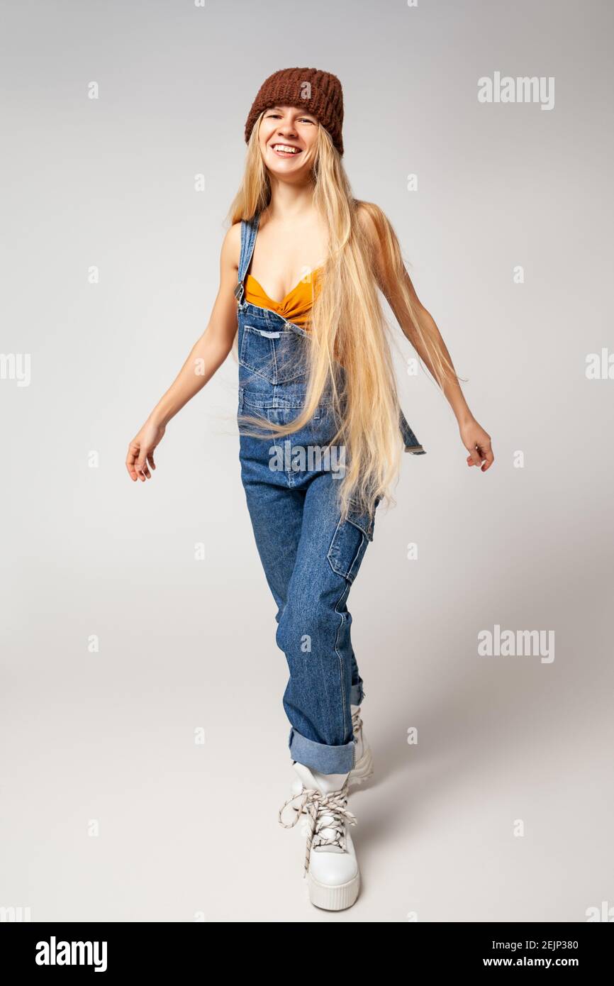 Energetic hipster woman in trendy wear dancing in studio Stock Photo