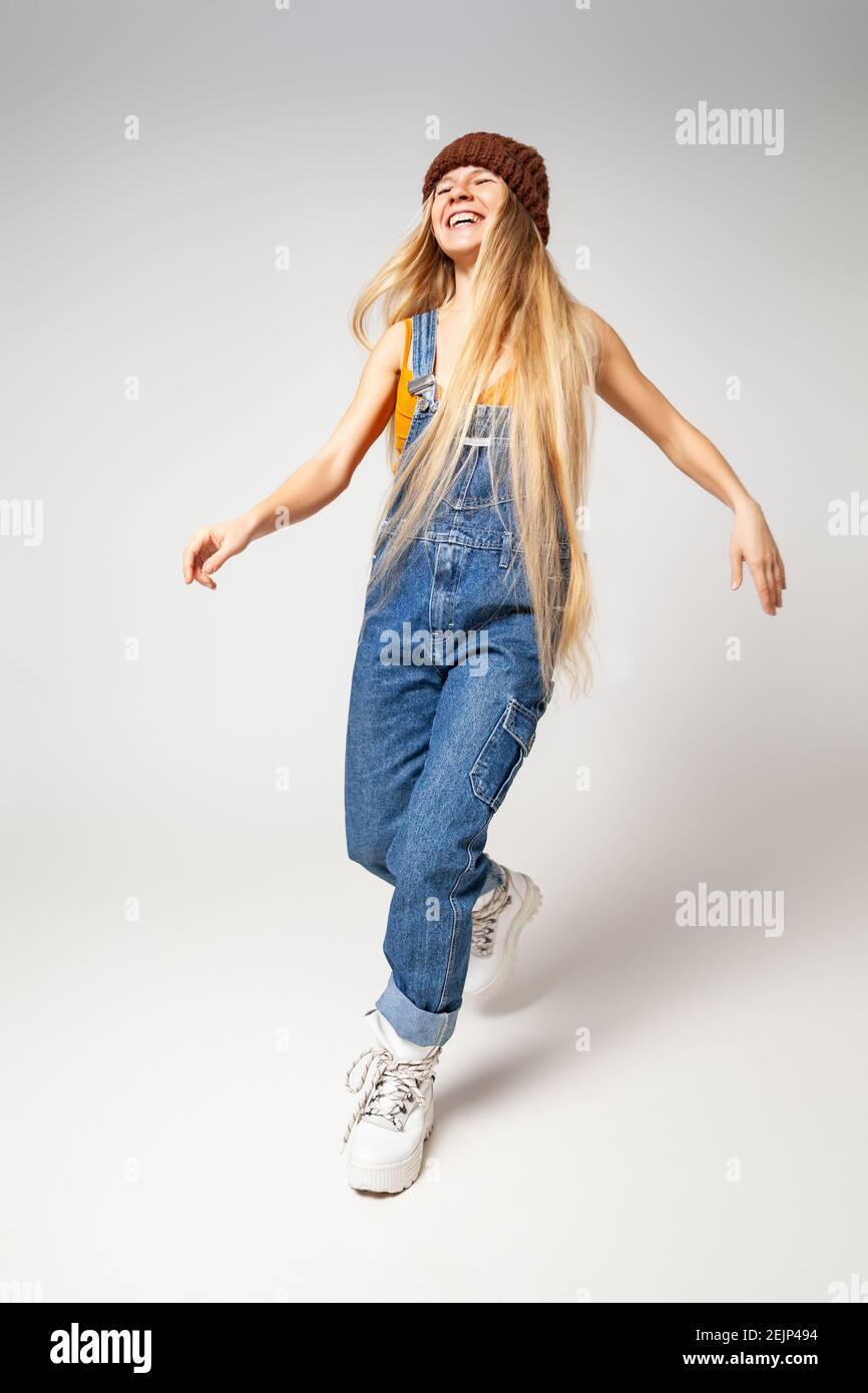 Energetic hipster woman in trendy wear dancing in studio Stock Photo