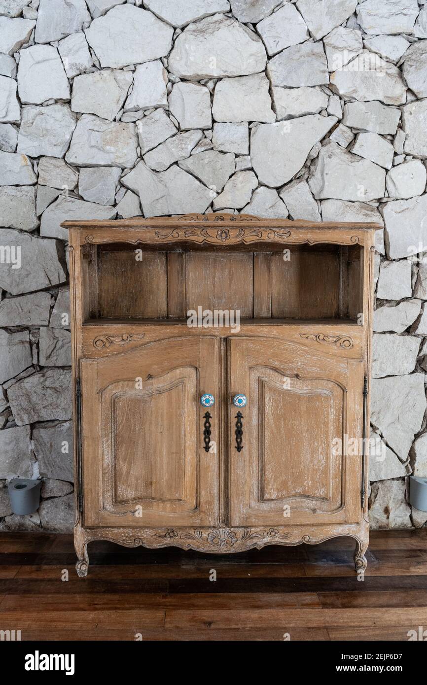 Wooden old small empty cabinet over a stone wall Stock Photo